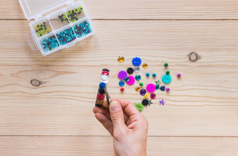 close-up-person-s-hand-sticking-colorful-beads-bracelet